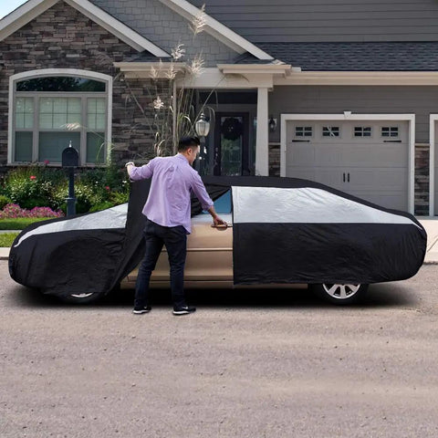 Man using Heavy Duty Waterproof Sedan Car Cover 186 To 202 Inches With Driver Side Zipper UV Protection in driveway.