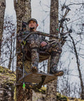 Hunter using Titan Sd Climbing Treestand With Roomier Design Bigger Top Seat Frame And Longer Foot Platform For Large Frame Hunters Supports Up To 350 Pounds Heavy Duty Premium Tree Stand With Five Year Limited Warranty in the forest.