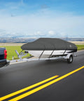 A truck towing a boat with a heavy-duty, black stormpro ski & wakeboard tower cover on a highway, clear sky, and open field backdrop.