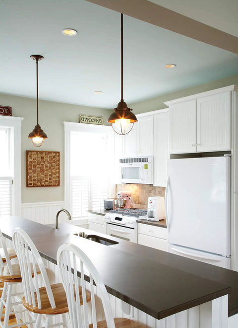 Modern kitchen interior with pendant lights above island, white cabinets, and high chairs