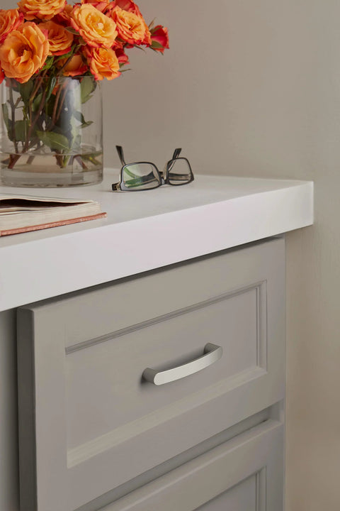 Contemporary Satin Nickel Cabinet Pull Rift Finish With Four And A Quarter Inch Overall Length And Three And Three Quarters Inch Center To Center Mounting Holes Ideal For Cabinets Drawers And Furniture Modern Drawer Handle installed on a gray cabinet with orange flowers.