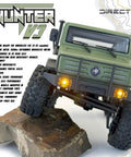 Built Different 1/18 Scale Brushless Rc Truck Crawler Rtr Matte Green Painted Shell on rocky terrain with bright lights.