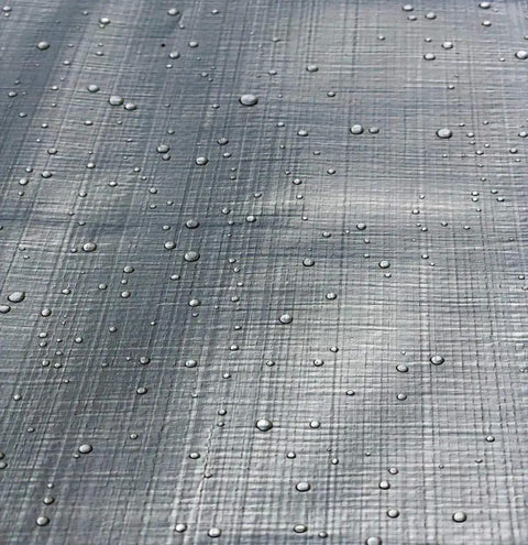 Close-up of Heavy Duty Reversible Tarp 16 by 20 in Silver Brown, 10 Mil Polyethylene with water droplets emphasizing weatherproofing