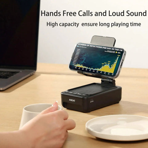 Phone Stand With Bluetooth Speaker And LED Color Changing Light on desk holding smartphone, coffee cup nearby