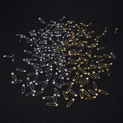 Kickass Assorted Steel Safety Pins Bulk Kit For Sewing Tailoring And Crafting with silver and gold safety pins on a black background.