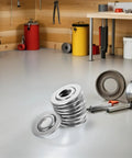 30 Pcs Stainless Steel Fire Sprinkler Cover Plates With Slick Silver Dual Disc Design For Stress Free Installations That Mask Unsightly Patch Marks And Stay Built Tough On Job Sites Or Home Ceilings stacked in a workshop.