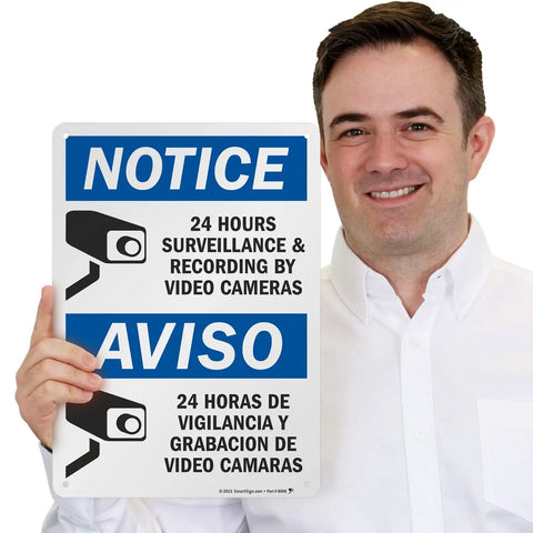 Skip The Drama Outside With Our 24 Hour Video Surveillance Sign 10X14 Inch Durable Aluminum Outdoor Security Plaque held by a smiling man.