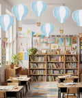 Blue White 6 Pack Hanging Hot Air Balloon Paper Lanterns Set in classroom with bookshelves and decorations