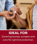First aid kit refill close-up: adhesive bandage applied to a child's finger by an adult