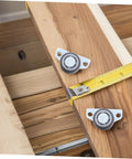 Set Of Four Adjustable Door Wheel Rollers For Sliding Closet Barn Doors With Heavy Duty Silent Pulleys Quick No Sweat Side Or Vertical Mount Hardware For Movable Furniture And Cabinets attached to wood with a measuring tape.