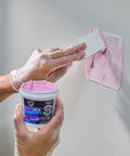 Person applying DryDex Spackling Wall Repair Patch Kit with pink to white dry time indicator on wall, 8 oz container visible