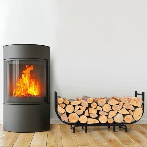 Curved Firewood Rack, 48-Inch Heavy Duty Log Holder For Indoor And Outdoor Use next to a lit fireplace, black metal design.
