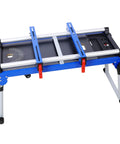 Built Tough Miter Saw Stand And Five In One Folding Portable Workbench With Telescoping Height Legs And Smooth Roll Caster Wheels For Woodworking And Masonry In Blue, featuring adjustable clamps and durable steel frame.