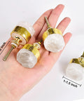 Four Pack Real Deal Natural Clear Quartz Crystal Cabinet Knobs With Gold Plated Solid Brass Base For Drawers And Dressers Smooth Everyday Premium Hardware in hand, size 1-1.5 inch, showing detail.