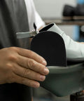 Person attaching No Slip Heel Patches For Boots And Sneakers Rubber Heel Pad Repair Patches Black Sole Protectors to shoe.