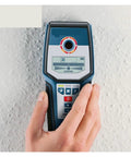 Heavy Duty Stud Finder Wall Scanner With Hella Precise Targeting For Locating Wood Studs Copper Wiring And Steel Rebar In Drywall Or Concrete Walls Offering Comfort Grip Design And Zero Guesswork For Weekend Warriors, hand-held on wall.