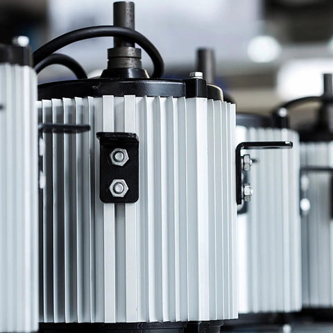 Industrial engines in a row, with visible cooling fins and bolts, showcasing mechanical detail.