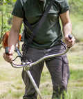 Man using Heavy Duty Trimmer Strap Harness For Weed Eater With Upgraded Elastic Part And Metal Clasp in a garden setting