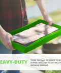 Person holding Beast Mode Durable Seed Starting Trays For Seedlings And Microgreens with bricks inside, showing tray strength