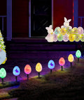 Night view of 20 LED Solar Easter Egg Lights Outdoor Stake With 25 Ft Cord, 8 Modes Waterproof Yard Pathway Garden Lights illuminating a pathway.