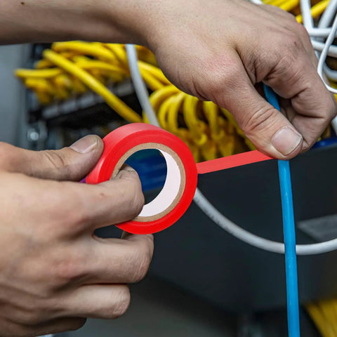 Hands using red electrical tape on a blue wire among yellow cables for safety in electrical work. Professional Grade 50 Piece Insulated Screwdriver Set Badass Electrician Tools 1000V VDE Rated Magnetic Tips T Handle Hex Wrench Top Shelf Rig For Real Tradesmen And DIY Crews.