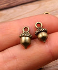 Hella Slick Screw Open Miniature Black Ebony Acorn Curios Set Of Two With Hidden Antique Bronze Pinecones close-up of bronze acorns.
