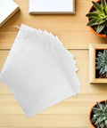 White Organza Gift Bags 100 Pack Drawstring Candy Bags for Party Favors on wood table with potted succulents