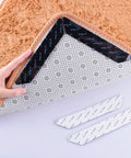 Person applying No Slip Carpet Gripper Kit 16 Pack Reusable Washable Rug Pads And Edge Clips For Floors And Cars to rug corner