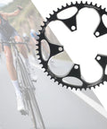 56T Black Narrow Wide Bike Chainring for 8 to 12 Speed Road Bikes, 110 BCD Aluminum, shown with cyclist in background