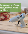 Glue gun on wooden table next to Crystal Clear Hot Glue Sticks 4 Inch 0.44 Inch Diameter 50 Pieces For Crafting Scrapbooking DIY Projects