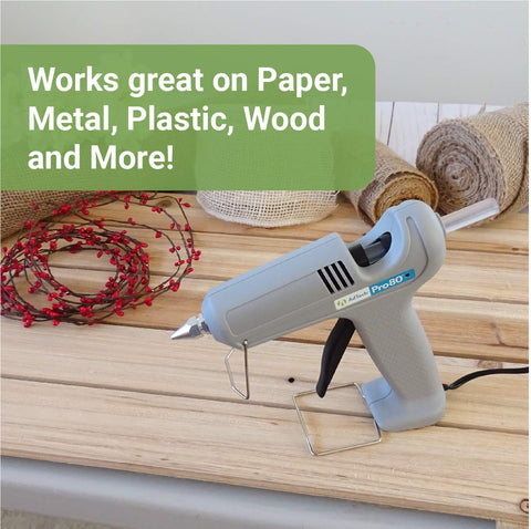 Glue gun on wooden table next to Crystal Clear Hot Glue Sticks 4 Inch 0.44 Inch Diameter 50 Pieces For Crafting Scrapbooking DIY Projects