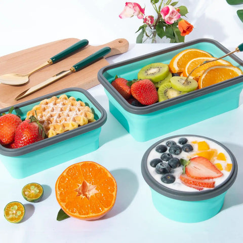 Eight Pack Collapsible Food Storage Containers With Lids filled with fruits, waffles, and yogurt on a table with a cutting board.
