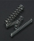 Close-up of three metal springs from Heavy Duty Coil Spring Kit with 600 Piece Spring Assortment, on a dark background