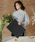 Woman holding Floral Wrapping Paper Sheets 10 Pack Embossed Kraft Paper for Bouquets and Gifts with flowers on a table