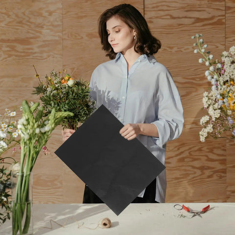Woman holding Floral Wrapping Paper Sheets 10 Pack Embossed Kraft Paper for Bouquets and Gifts with flowers on a table