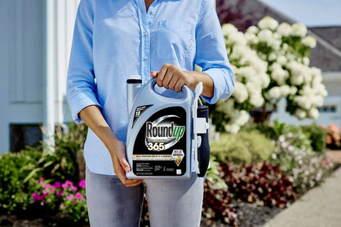 Person holding Ready To Use Weed Killer With Comfort Wand Max Control 365 Kills Weeds To The Root And Keeps Them Gone For Up To 12 Months 1.33 Gal Easy Spray For Driveways Yards And Garden Beds in a garden