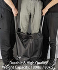 Demonstrating strength of Ultra Spacious 96L Travel Duffle Bag For Men And Women, carrying heavy load, black weatherproof nylon.