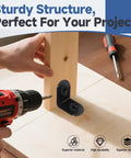 Person using a drill to install a black stainless steel L bracket for secure joint assembly in DIY project.