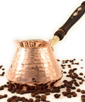 Hand Hammered Copper Turkish Greek Arabic Armenian Coffee Pot Large 18 Fl Oz Stovetop Cezve Jazzve Ibrik Briki Heavy Duty Coffee Maker For Loads Of Flavor Turkish Coffee Classic Hammered Design with wooden handle and coffee beans.