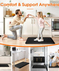 Kitchen Mat Cushy Thick Floor Comfort Mat With Non Slip Bottom Water And Stain Resistant Easy Clean Standing Desk Mat for kitchen sink and office 17.3x28 inches black, used under person in home kitchen setting.