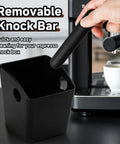 Person removing bar from espresso knock box beside a coffee machine, illustrating the removable bar feature.