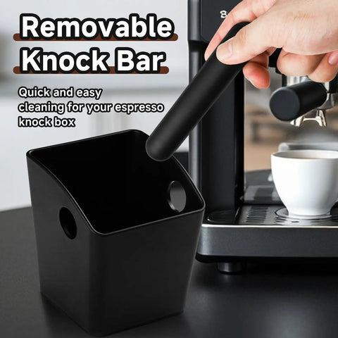 Person removing bar from espresso knock box beside a coffee machine, illustrating the removable bar feature.