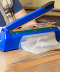 Packaging Pros Essential 2pcs Flat Ribbon Heating Strip For Plastic Bag Sealer, shown with blue sealer and plastic bags.