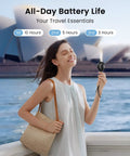 Woman holding Mini Portable Handheld Fan With 3 Speeds USB Rechargeable Personal Fan for travel, standing by water