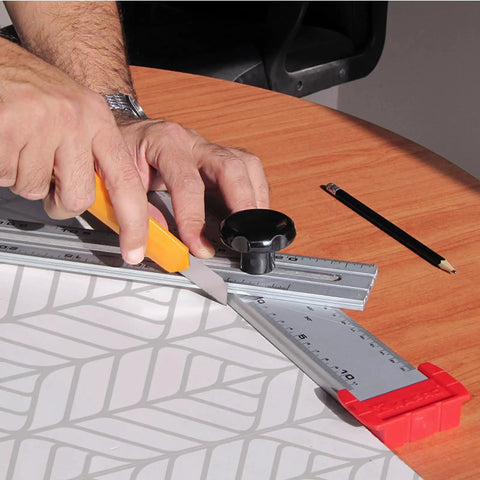 Using Tough As Nails 48 Inch Aluminum Adjustable Drywall T Square Tool with Fast Adjust Head for precise measuring on a table.