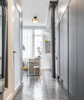 Loft Style Matte Brass Flush Mount Light With Black Canopy And Frosted Glass Shade in a modern hallway interior