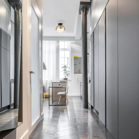 Loft Style Matte Brass Flush Mount Light With Black Canopy And Frosted Glass Shade in a modern hallway interior