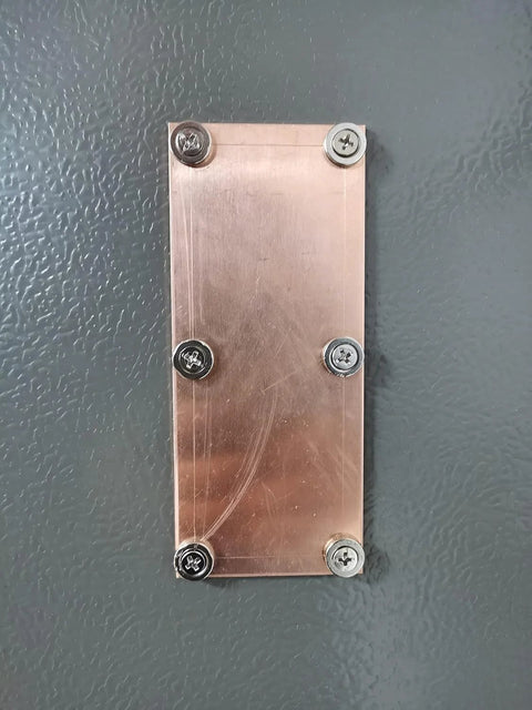 Magnetic copper spoon backer with screws mounted on surface for welding support, showcasing replaceable design for seamless welds.
