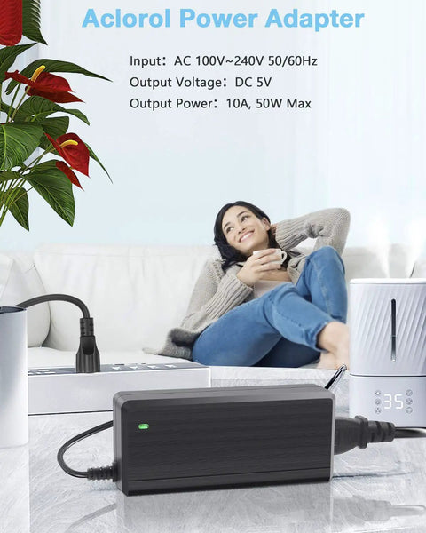 Beefy 5V 10A 50W LED Power Supply Adapter with 5.5x2.1mm plug and safety protections on table, woman relaxing in background.