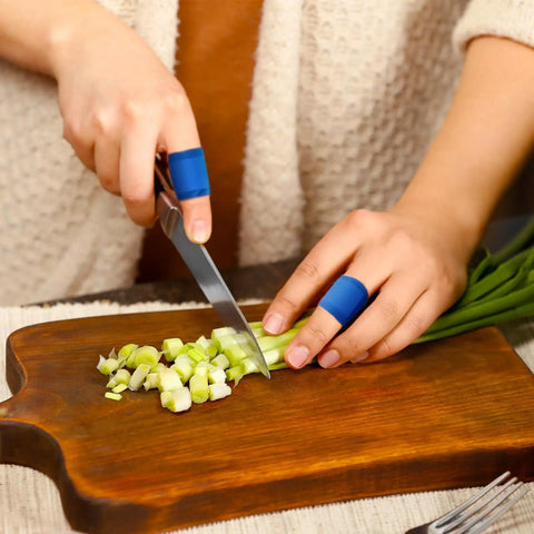 Person wearing 100 Pcs Blue Bandages 3 By 1 Inch Metal Detectable Waterproof PE Adhesive Bandages For Food Handling And Kitchen Use slicing vegetables
